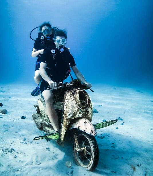 2 people on a motorized scooter underwater